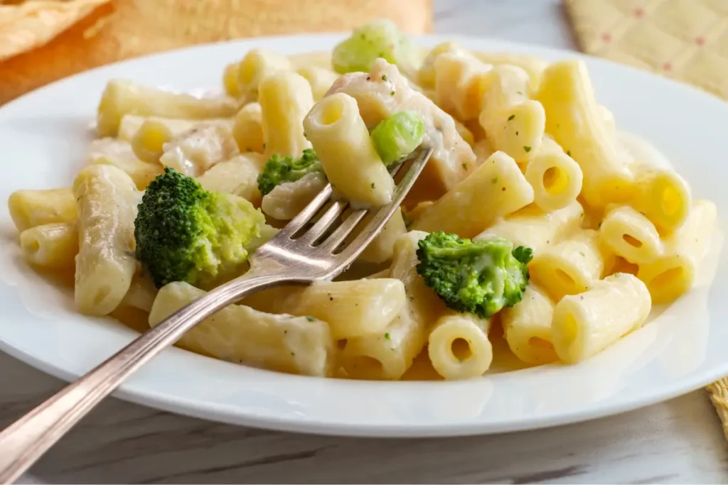 A plate of creamy chicken broccoli ziti with al dente pasta, succulent chicken pieces, and fresh broccoli in a rich sauce, ready to eat.